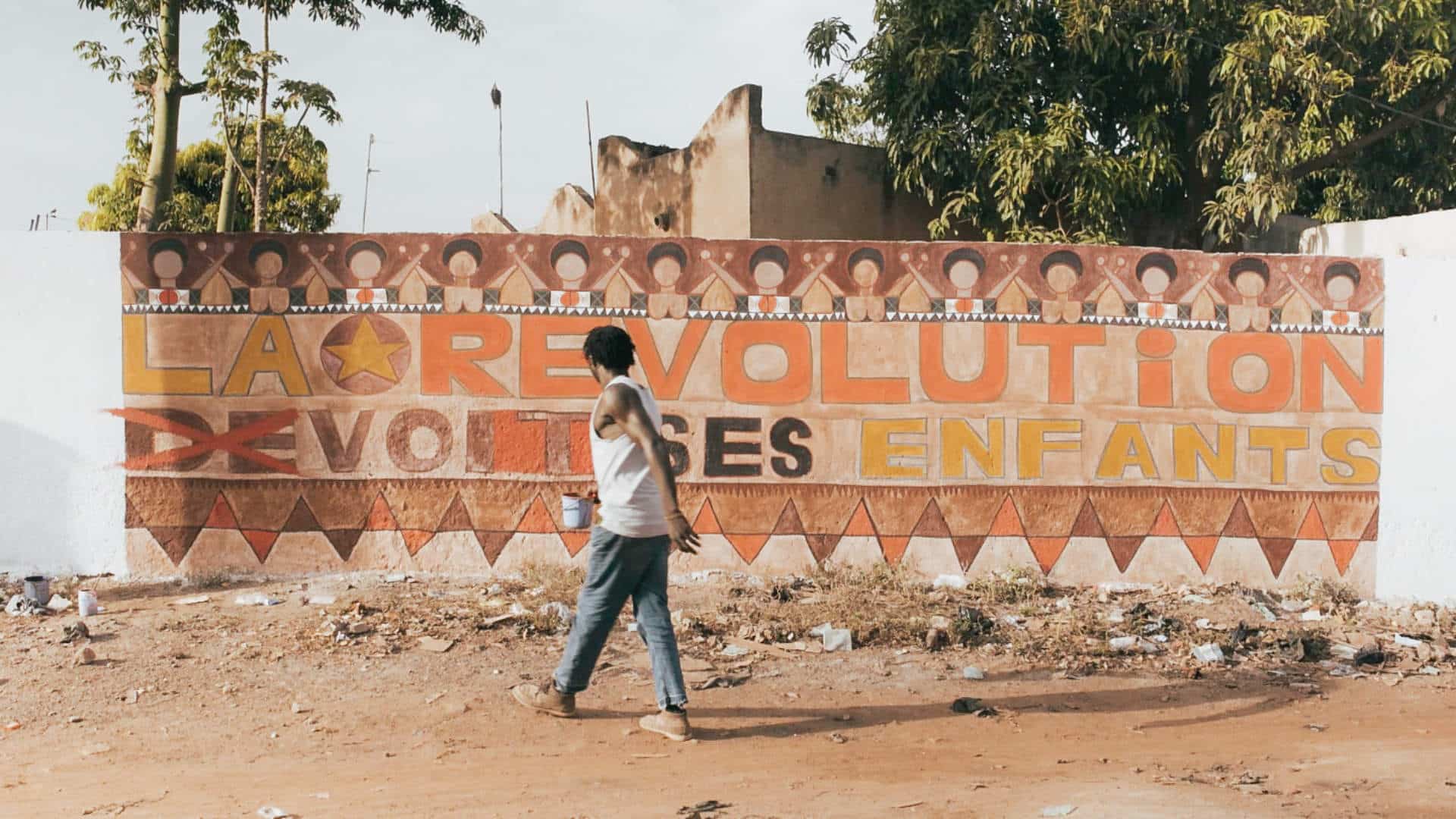 Titel „Die Revolution frisst ihre Kinder“ gemalt von dem burkinischen Künstler Wilfried de Paul c Schauspielhaus Graz Jennifer Weiss
